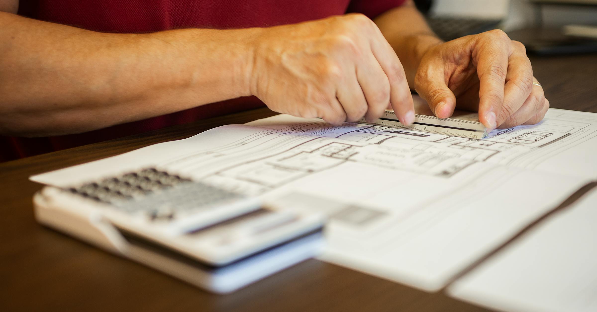 Architect measuring blueprints on a desk for construction estimating